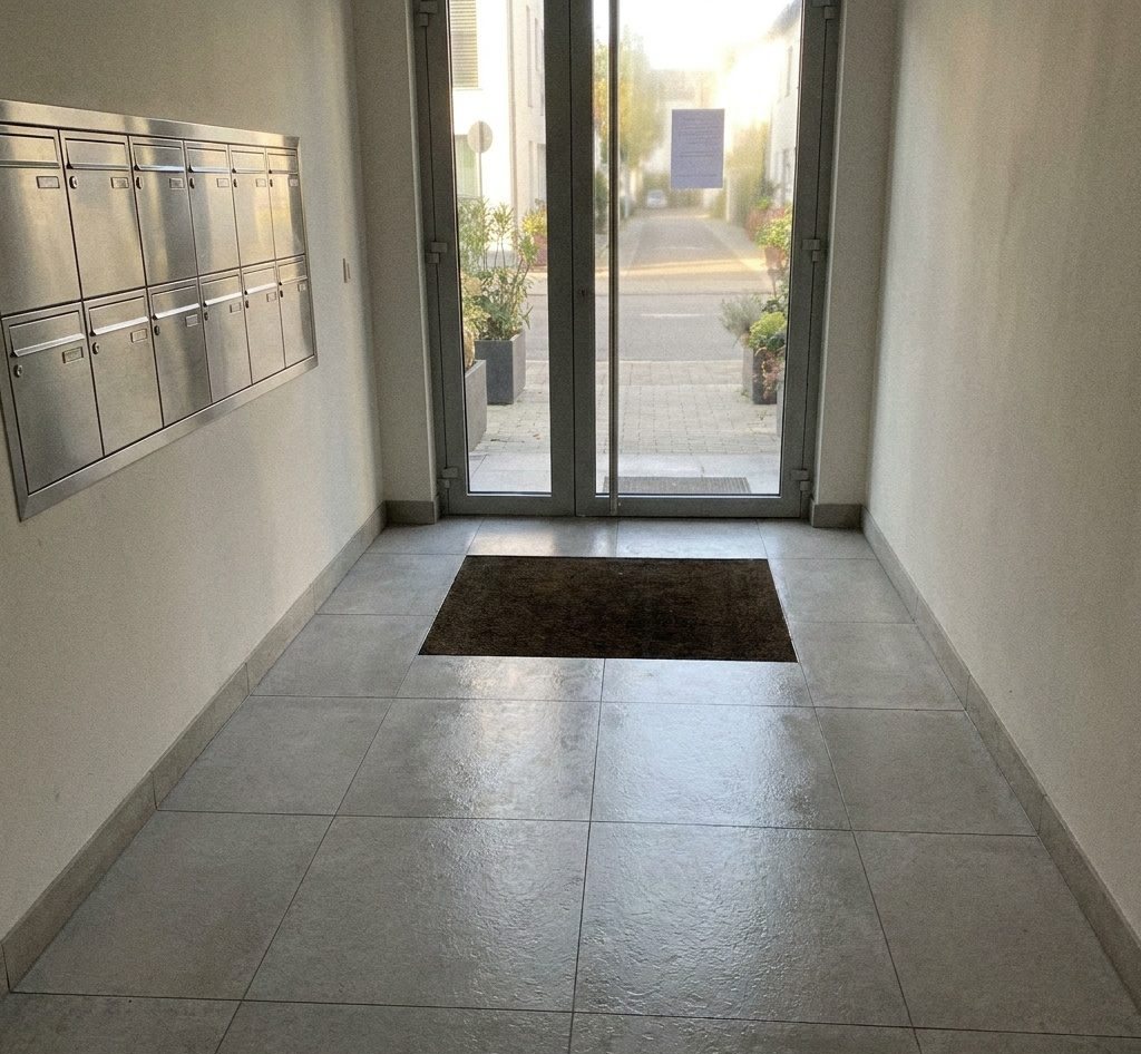 Photo horodatée d'un hall d'immeuble propre, prise après le passage de l'équipe